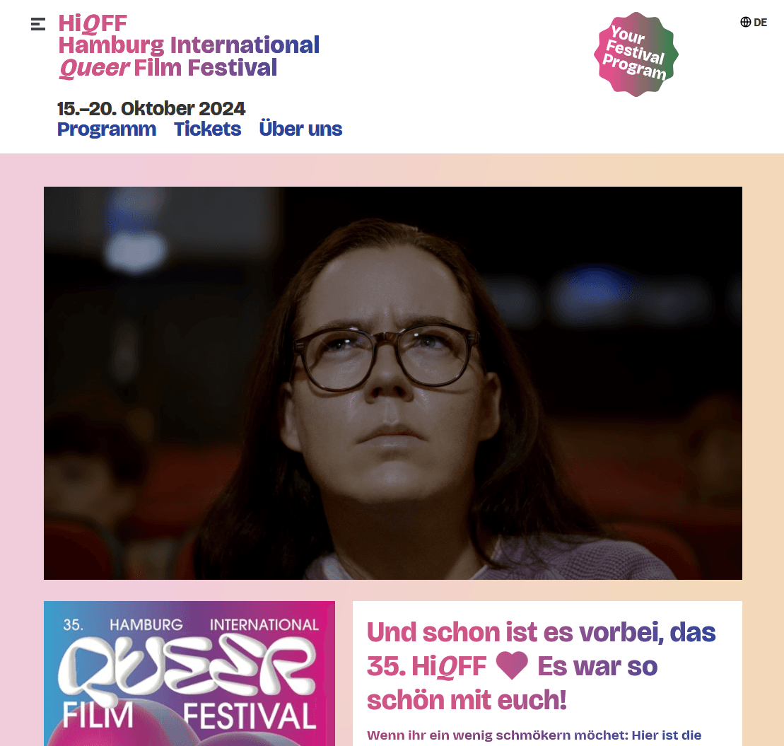Startseite der Website des Hamburg International Queer Film Festival mit einem großen Videoblock auf dem eine Person im Kino auf eine Leinwand schaut.